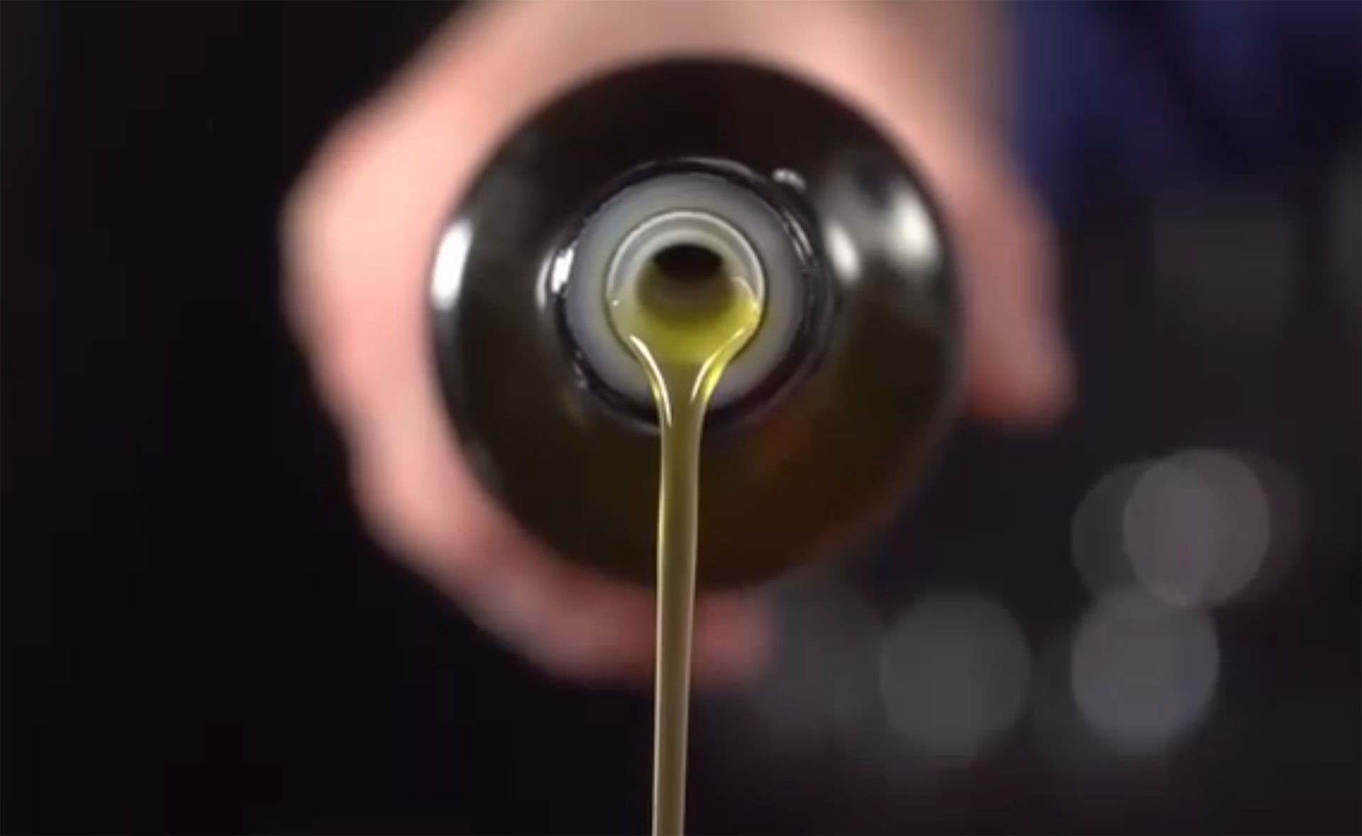 Aceite de oliva virgen extra vertiéndose en una botella